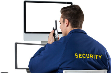 Security officer talking on walkie talkie while looking at computer monitors