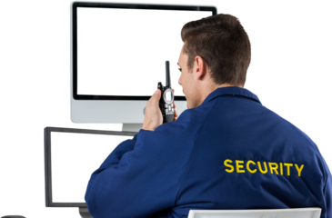 Security officer talking on walkie talkie while looking at computer monitors