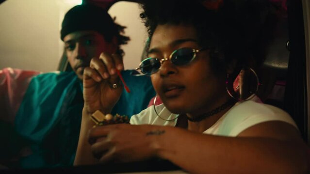 Stylish African American woman with ice cream in car.