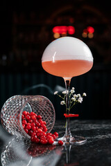 cocktail with red berries and smoke above the glass
