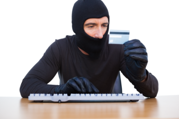 Burglar with balaclava hacking a laptop