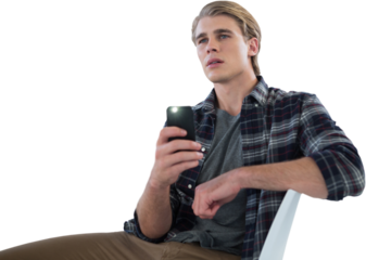 Businessman photographing with mobile phone while sitting on chair