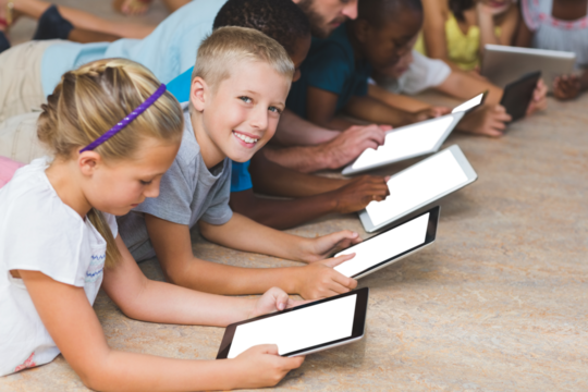 Teacher and kids lying on floor while using digital tablet in library - Powered by Adobe