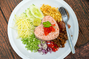 Rice with vegetables , Kho Kluk kapi , Thai food Rice mixed shrimp past serve with sausage ,dries shrimp , cucumber, chili yard long bean . Top view