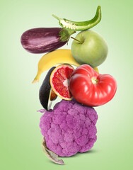 Stack of different vegetables and fruits on pale light green background