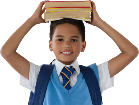 Smiling schoolboy carrying books on head over white background