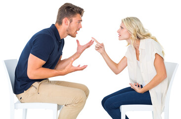 Young couple sitting in chairs arguing
