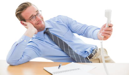 Irritated businessman holding telephone at desk