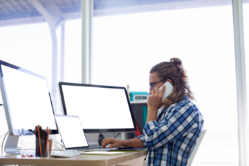 Side view of male executive talking on mobile phone while working at desk