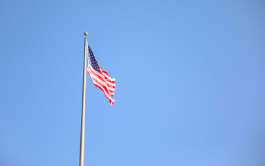 The US flag on a pole is a symbol of patriotism and unity, representing the country's values, history, and people. Its design and colors have symbolic meaning