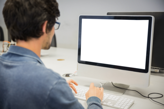 over the shoulder view of of serious casual man working at computer desk