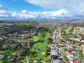 Fototapeta premium Aerial view of residential neighborhood surrounded by golf and valley during cloudy day in Rancho Bernardo, San Diego County, California. USA. 