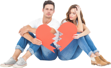 Young couple sitting on floor with broken heart shape paper