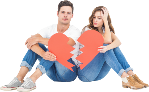 Young couple sitting on floor with broken heart shape paper