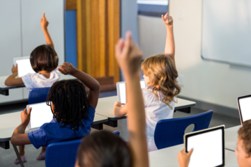 Students holding digital tablet in classroom