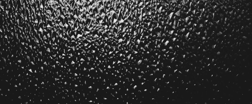 Corrugated window glass with light reflection in night. Atmospheric monochrome dark background. Shiny rippled glass glow in darkness close up. Detailed embossed texture in macro with copy space.