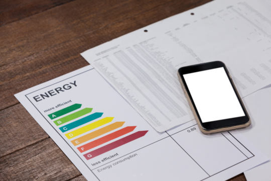Energy efficiency rating and mobile phone on wooden table