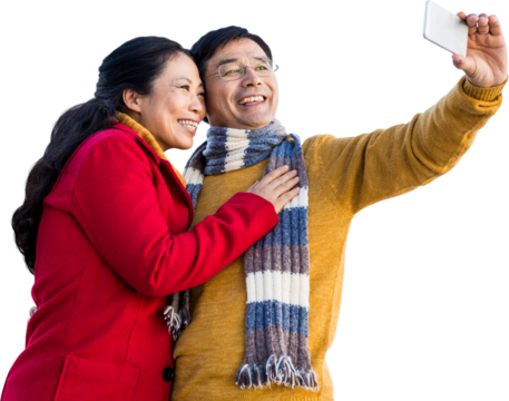 Older asian couple on balcony taking selfie