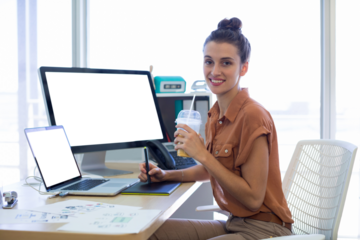 Portrait of female executive working over graphic tablet in office