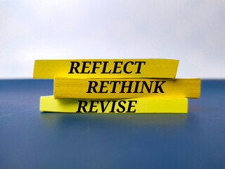 Yellow book with the word REFLECT RETHINK REVISE.