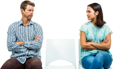 Displeased couple looking at each other while sitting on chairs