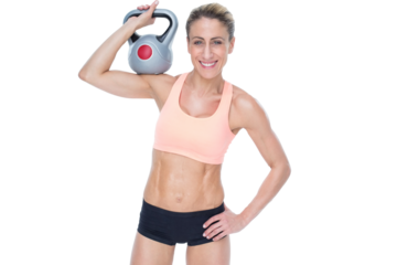 Female blonde crossfitter holding kettlebell smiling at camera