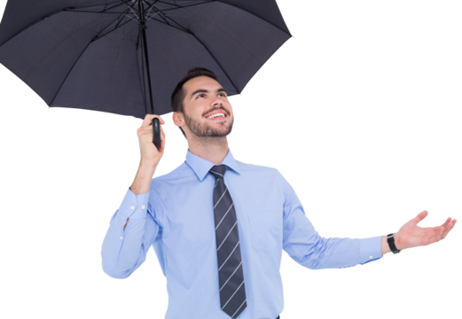 Happy businessman sheltering with a black umbrella