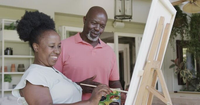 Happy senior african american couple painting in slow motion