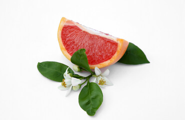 Cut fresh ripe grapefruit and green leaves on white background