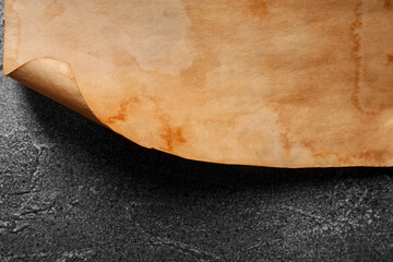 Sheet of old parchment paper on gray textured table, closeup
