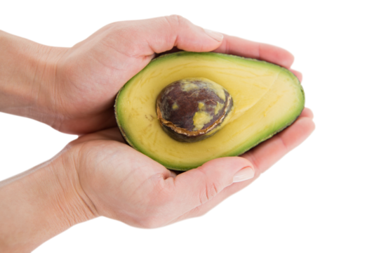 Woman holding half of an avocado 