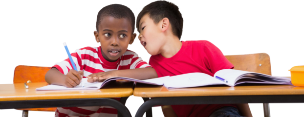 Cute pupils writing at desk in classroom
