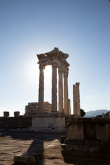 Fototapeta premium Ruins of the Temple of Trajan the ancient site of Pergamum (Pergamon). Izmir, Turkey. Ancient city columns with the sun in the background.