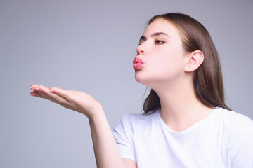 Kiss. Portrait of cute lovely girl sending blowing kiss with pout lips isolated on studio background. Affection feelings concept. Portrait pretty woman sends air kiss. Blowing air kiss.