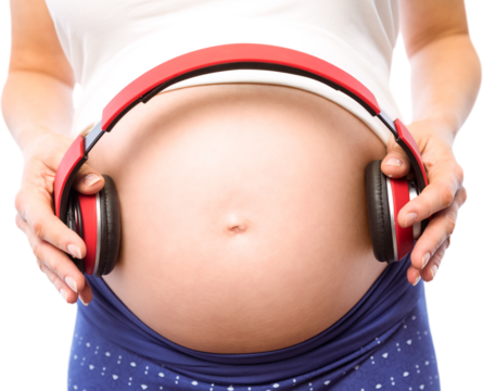 Pregnant woman holding earphones over bump