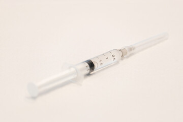 Fototapeta premium Close up needle syringe on white ground. Selective close of needle. Open space area. 