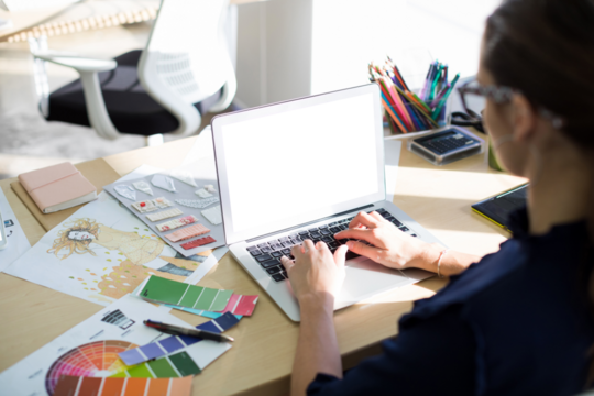 Female executive using laptop while sitting at desk - Powered by Adobe