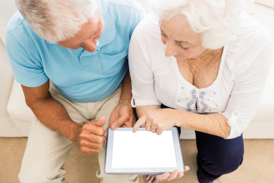 Focused senior couple using tablet