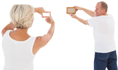 Mature couple hanging up picture frame