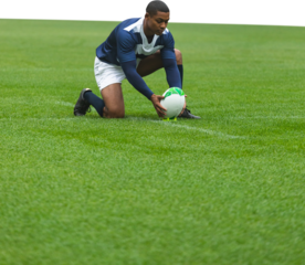 Male rugby player placing the ball