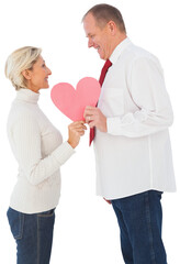 Older affectionate couple holding pink heart shape