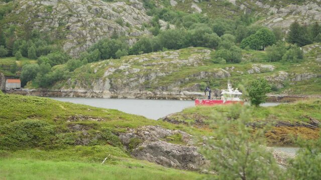 Catamaran Workboat Sailing Across Fjord Against Rocky Mountains In Norway. wide