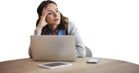 Thoughtful businesswoman looking away while sitting with laptop at desk