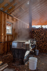 Boiling maple syrup over a wood fired boiler in a maple sugar shack in Ontario, Canada