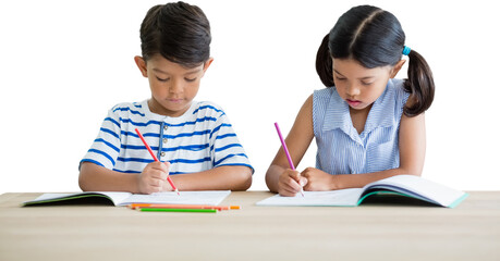 Children writing on books at table