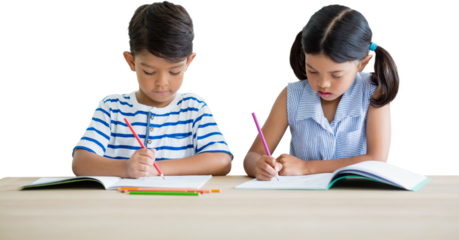Children writing on books at table