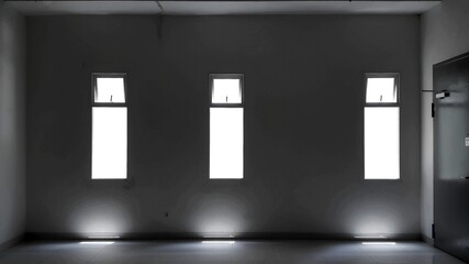 Empty room with a door and three window with sunlight. Black and white image.
