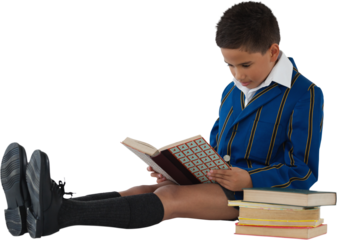 Focused schoolboy reading book