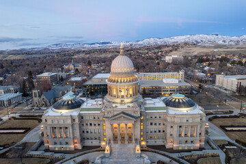 Idaho State Capitol in Boise with background of snow mountains at dusk 