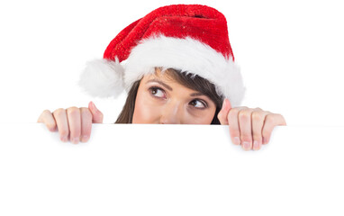 Festive brunette holding a poster while looking up